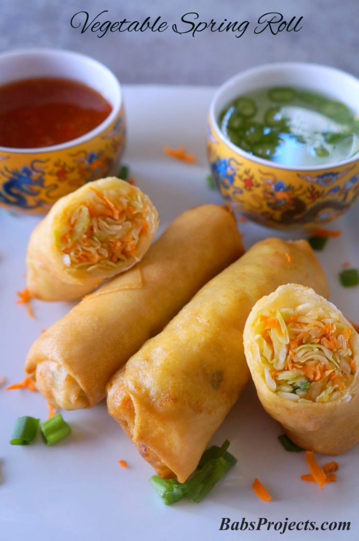 Vegetable Spring Roll on White Plate with Spicy Sauce and Green Chili in Vinegar