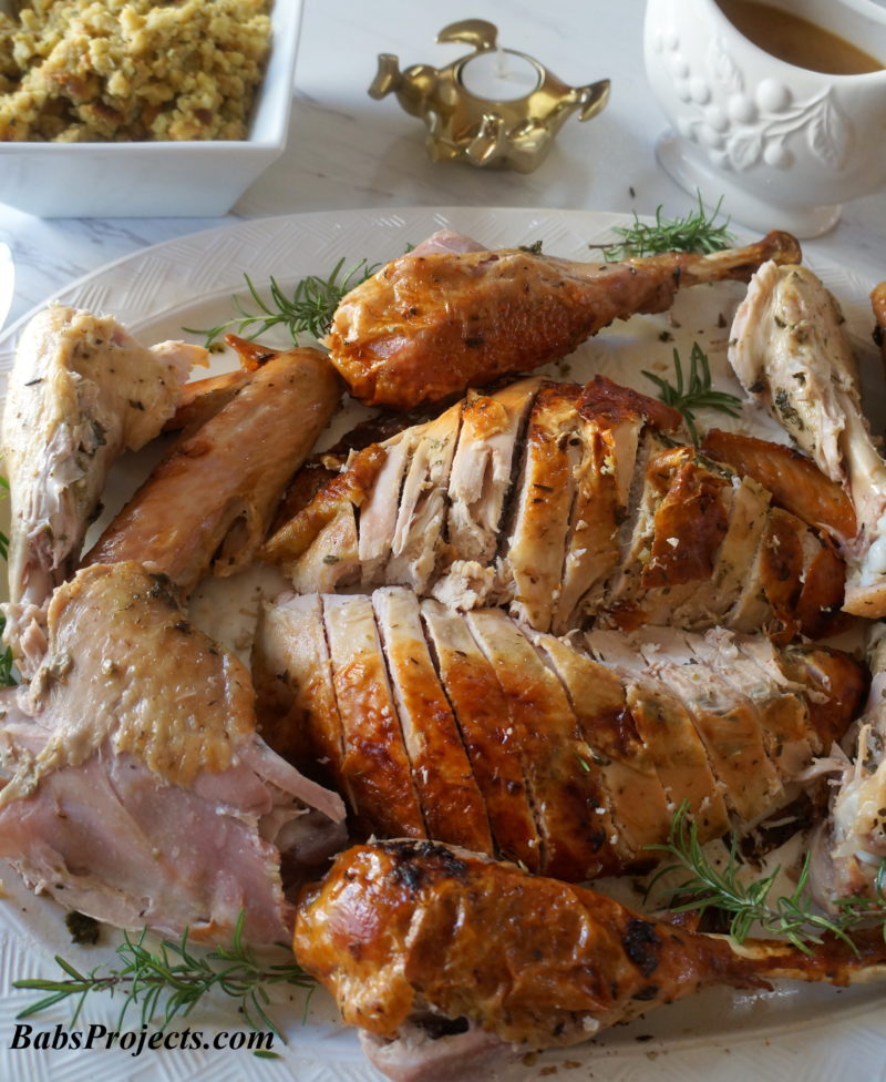 Perfect Herb Roasted Turkey Sliced on a White Platter for Thanksgving