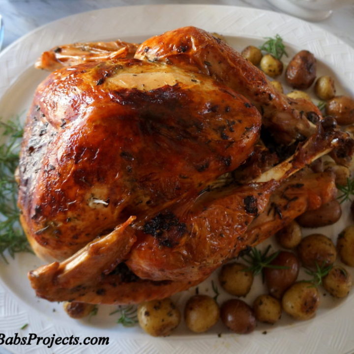 Herb Roasted Turkey on a Platter with Roasted Potatoes on the Side