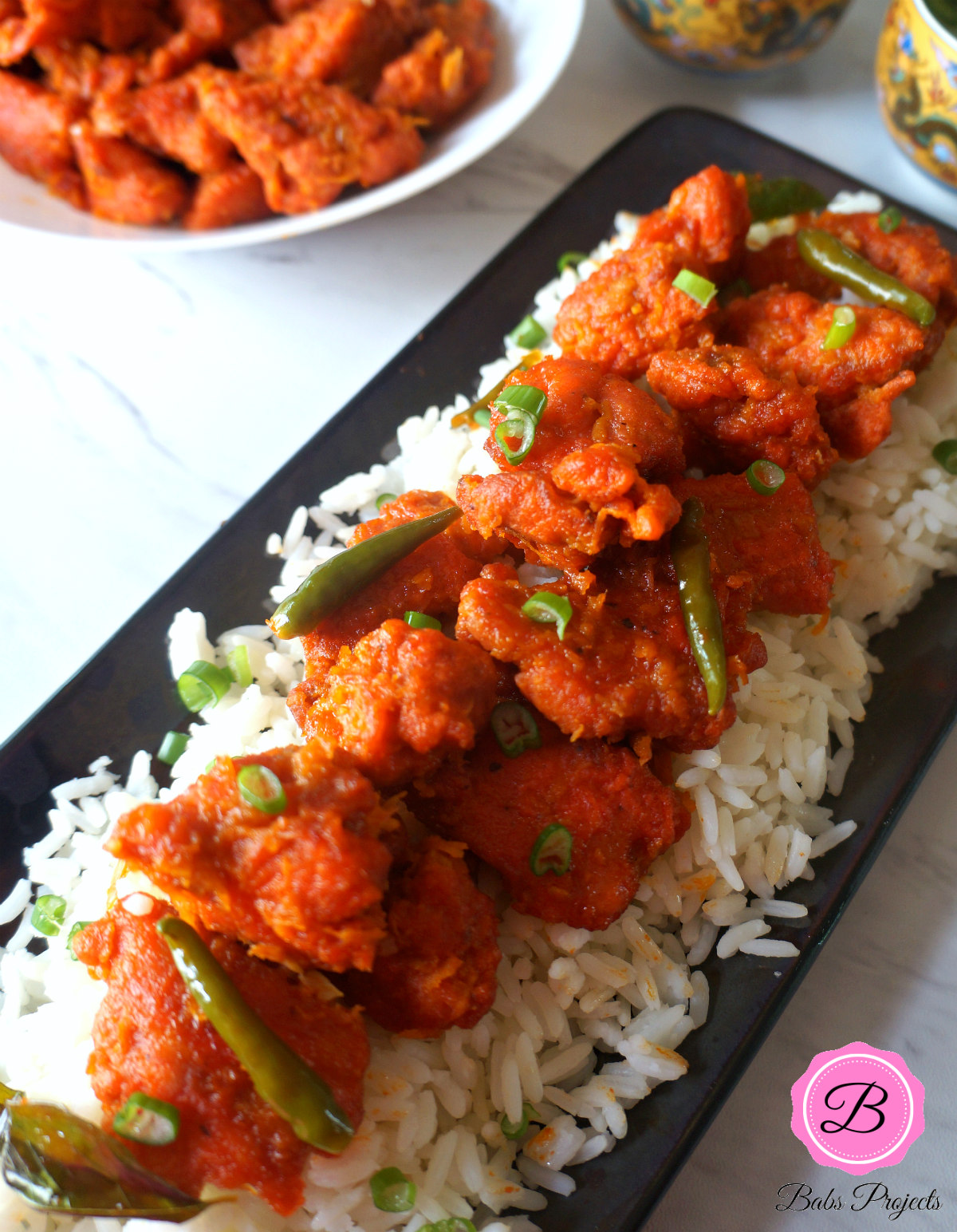 Fried Chicken Chili on a Bed of Rice Over Black Platter