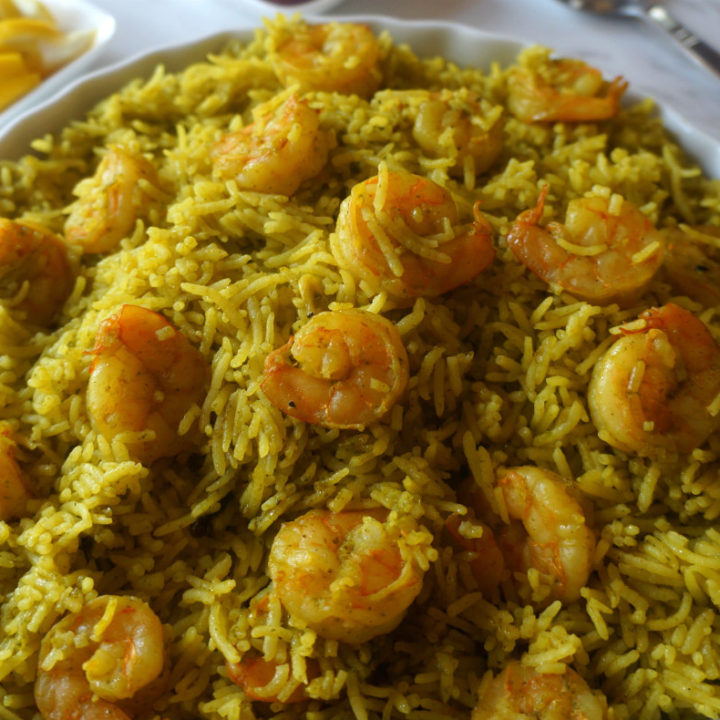 Green Masala Shrimp Pulao in a Pie Platter with Serving Spoon on the Side