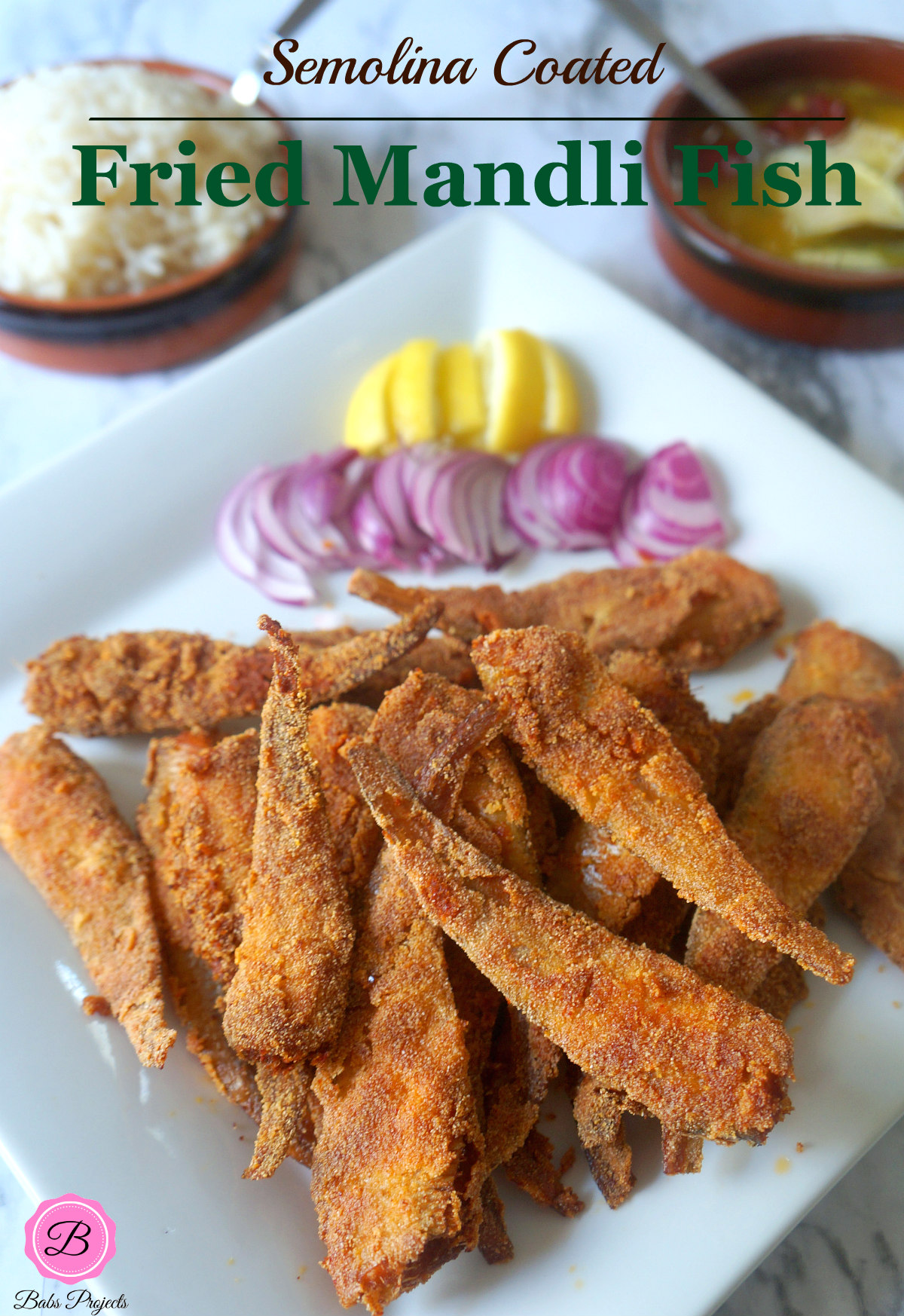 Crispy Fried Mandeli Fish on a White Platter with Sliced Onions and Lemon on the Side