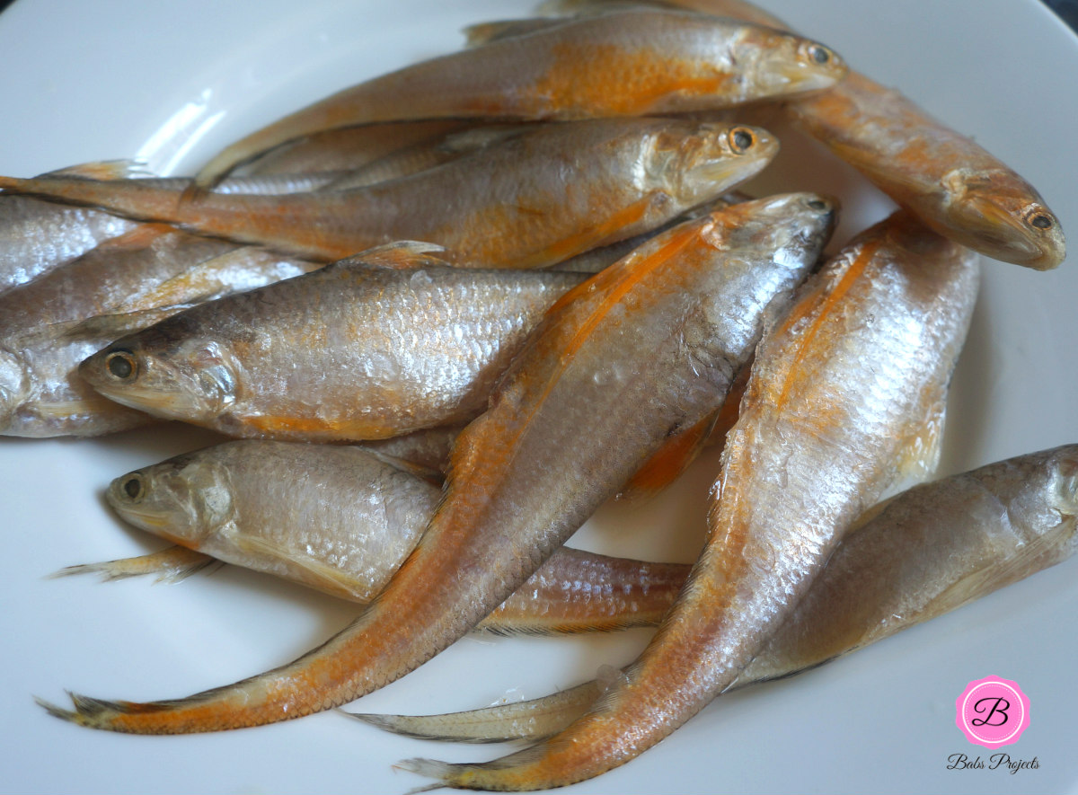 Whole Mandeli or Goldspotted Anchovies on a White Plate