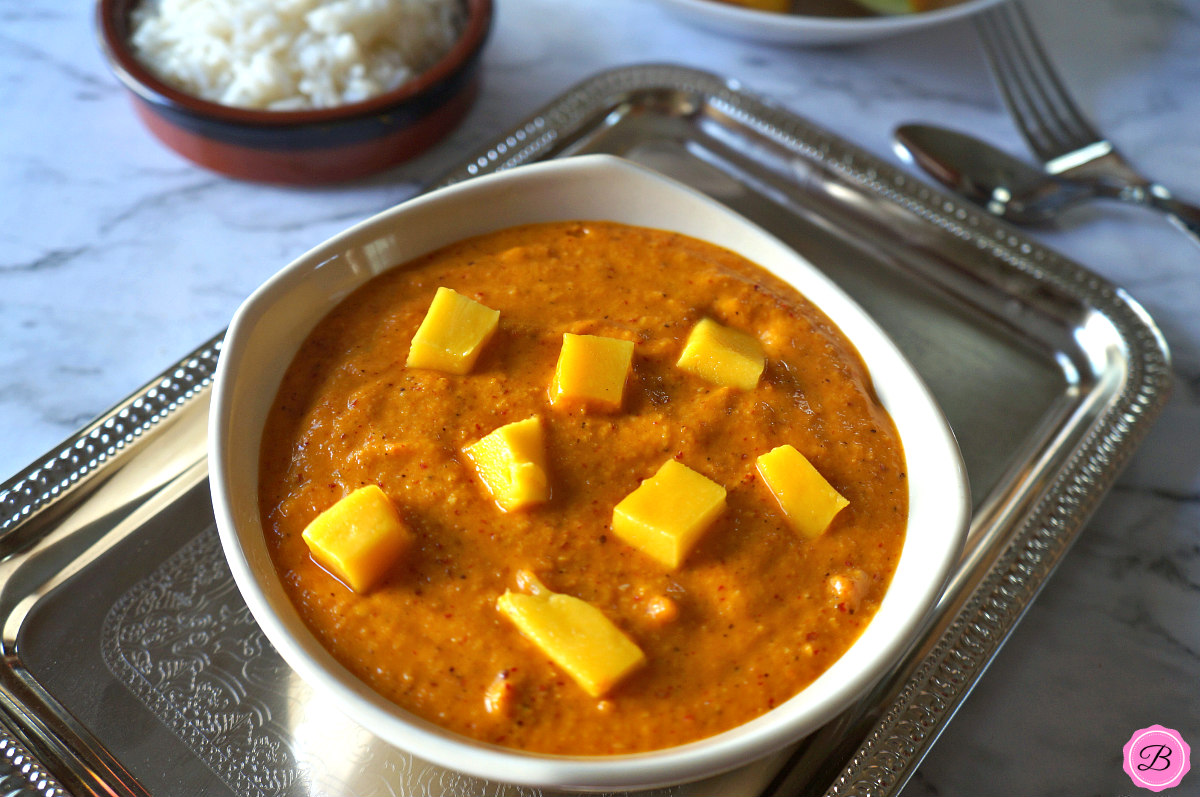 Sweet Mango Chutney in a Bowl on A Stainless Steel Tray with Rice and Mango Slices on the Side