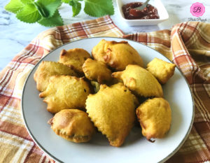 Ajwain Leaf Pakora (Sambarballi Bhajje) on a White Plate and Some Green Leaves and Ketchup on the Side