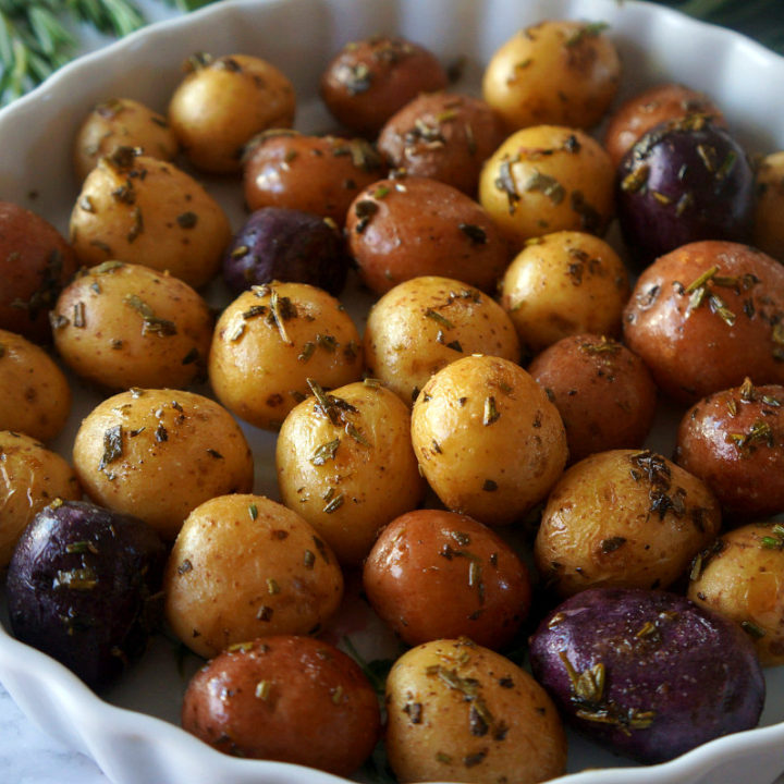 Herb Roasted Baby Potatoes in a Pie Dish with Herbs on the Side