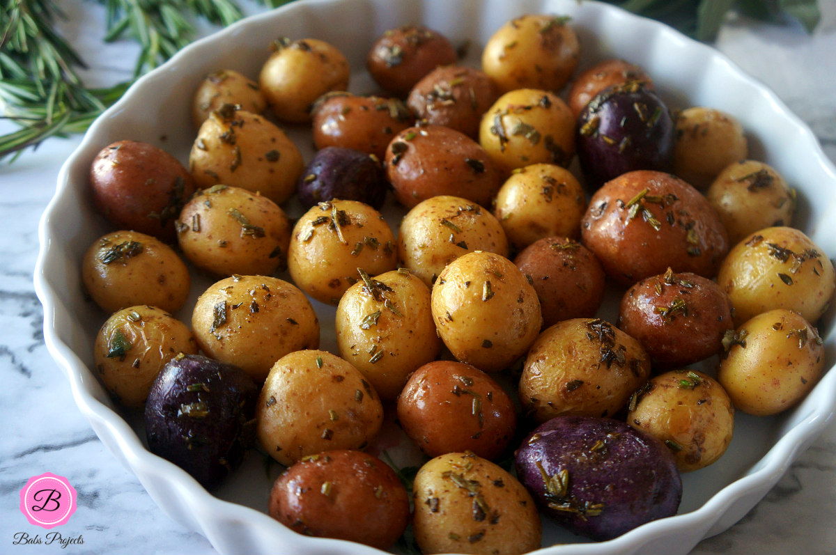 Herb Roasted Baby Potatoes in a Pie Dish with Herbs on the Side