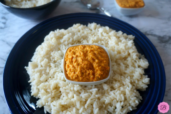 Raccha Dha Chutney in a White Bowl with Rice Around it in a Blue Plate