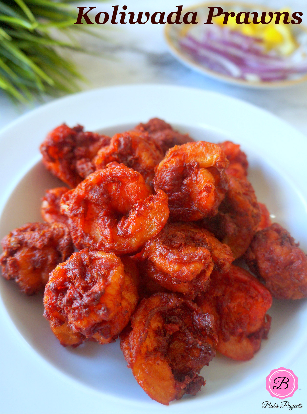 Koliwada Prawns in a White Bowl with Sliced Onions and Lemon on the Side