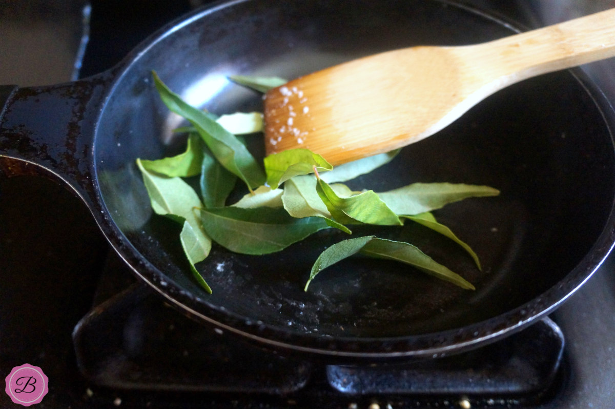 Curry Leaves on a Fry Pan with Wooden Spatula