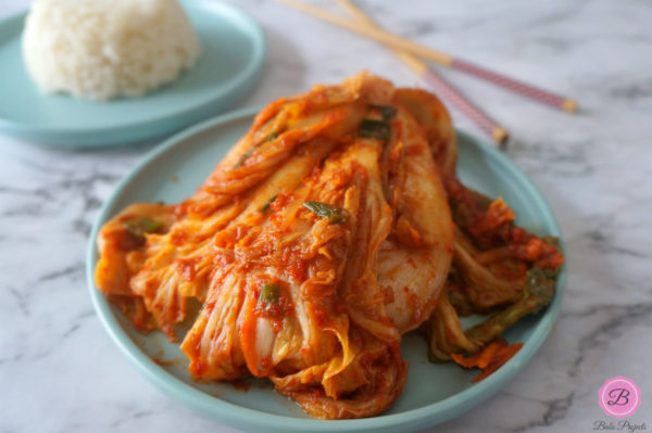 Napa Cabbage Kimchi on Blue Plate with Rice and Chopsticks