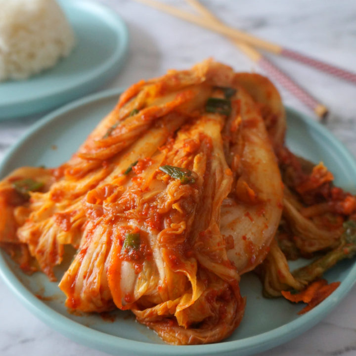 Napa Cabbage Kimchi on Blue Plate with Rice and Chopsticks