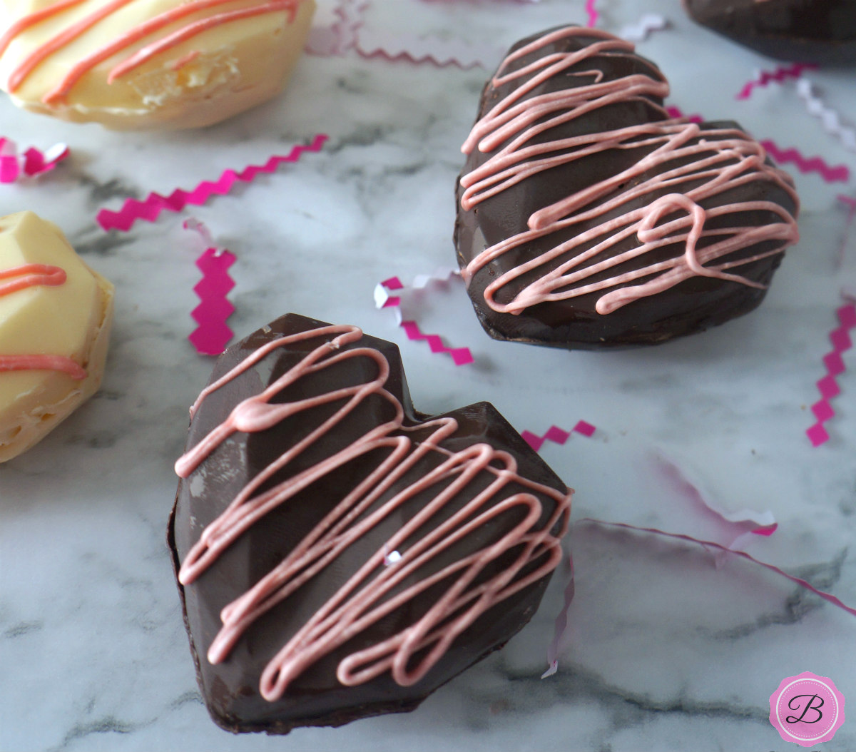 White Chocolate and Heart Hot Chocolate Bombs with Pink Icing on Top