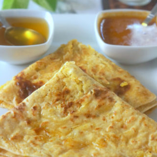 Two Triangle Shaped Puran Poli on a White Plate