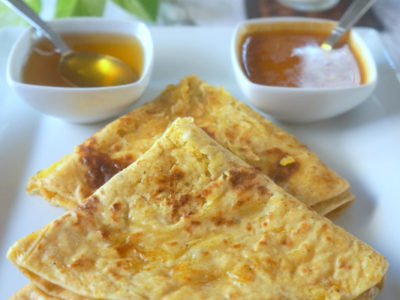 Two Triangle Shaped Puran Poli on a White Plate