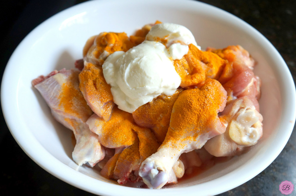 Marinating Chicken with Turmeric and Yogurt in White Bowl