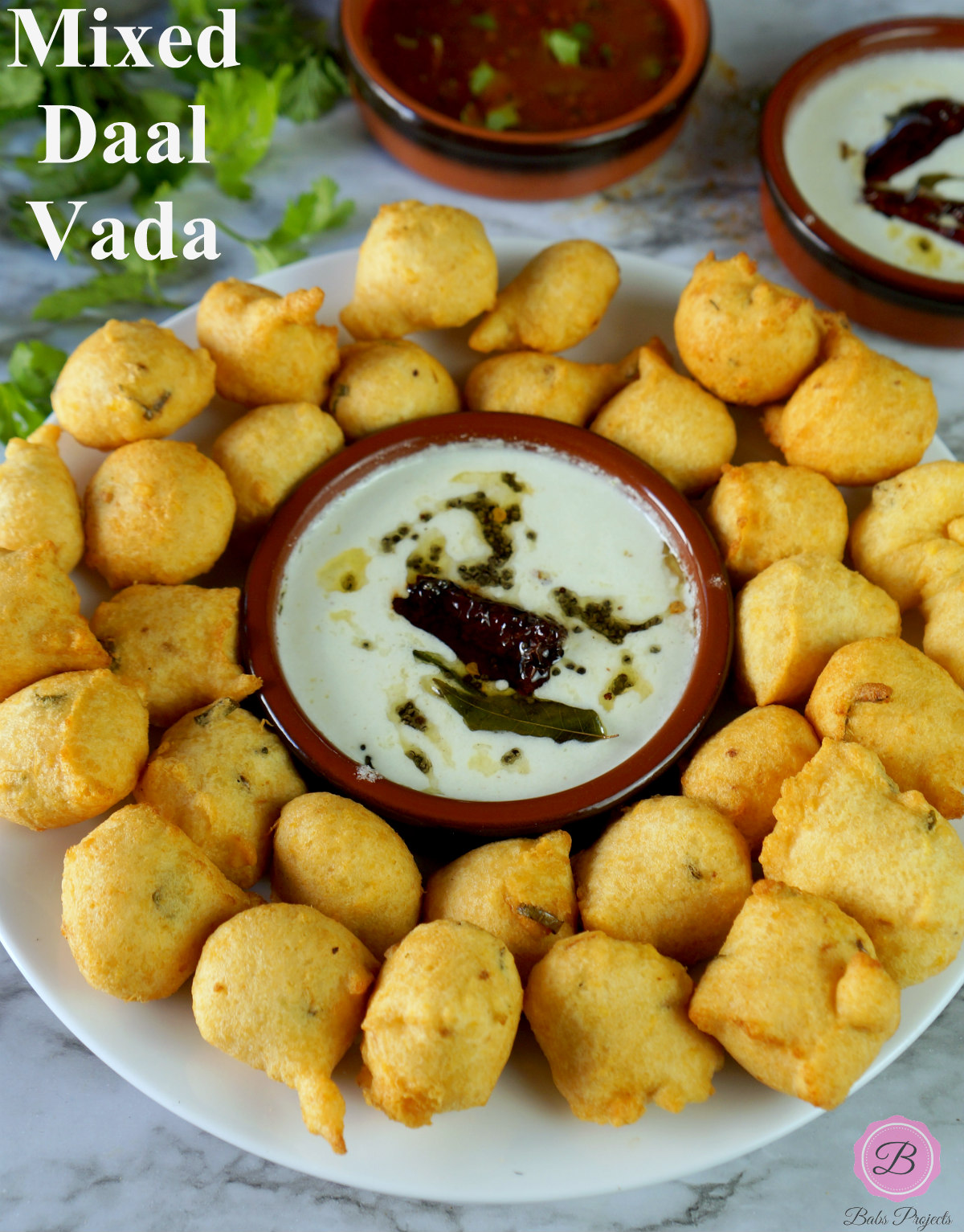 Mix Daal Vada Served in a White Plate with Coconut Chutney in the Center