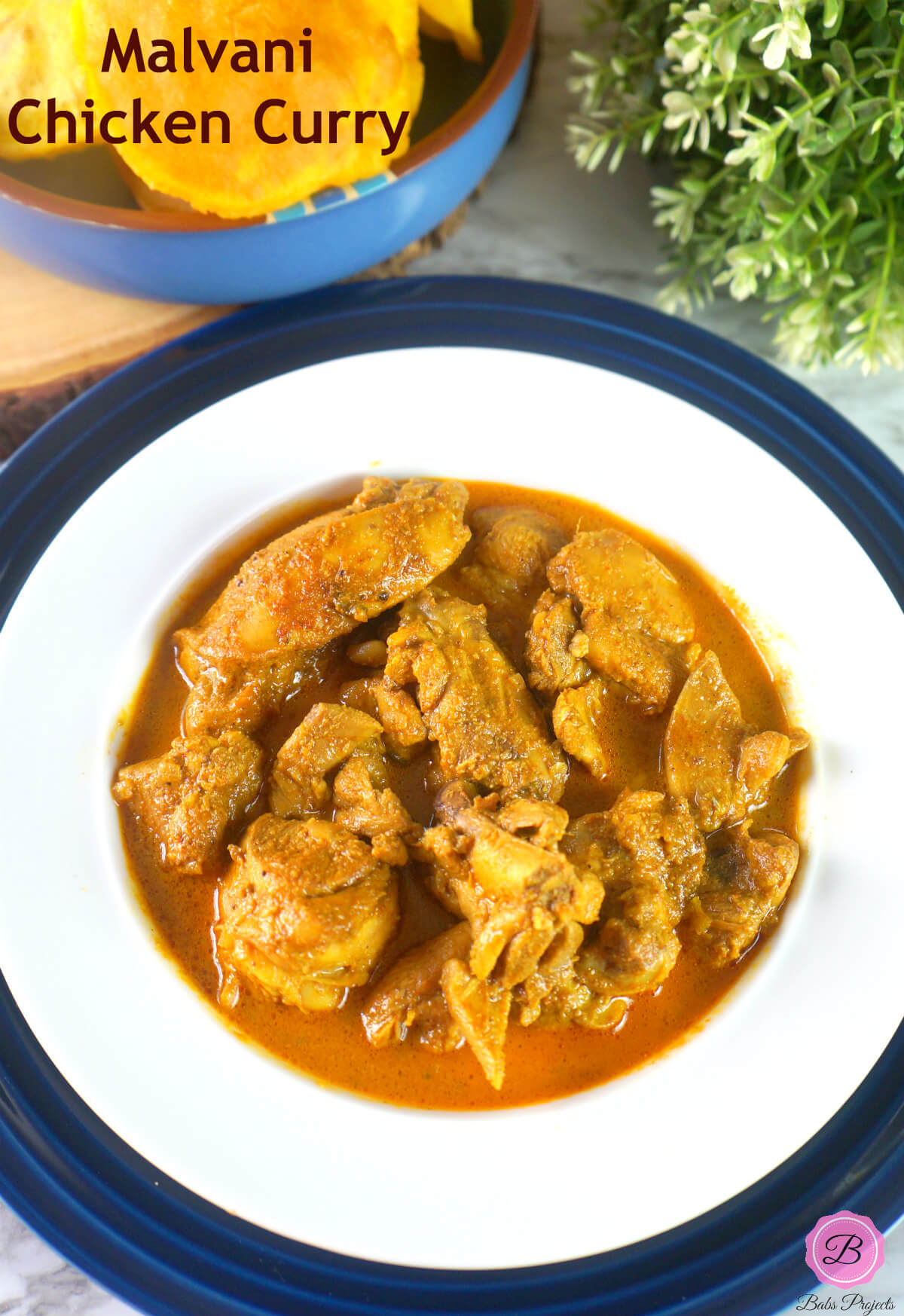 Malvani Chicken Curry in a White Bowl with Vade on the side