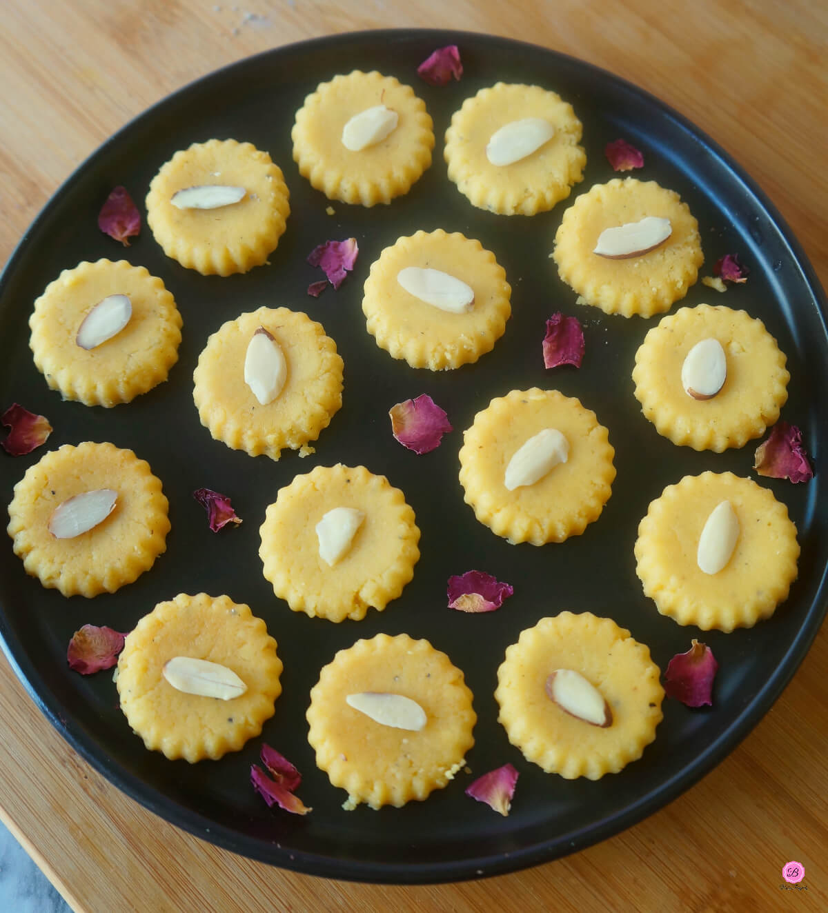 Mango Peda on a Black Platter Garnished with Rose Petals